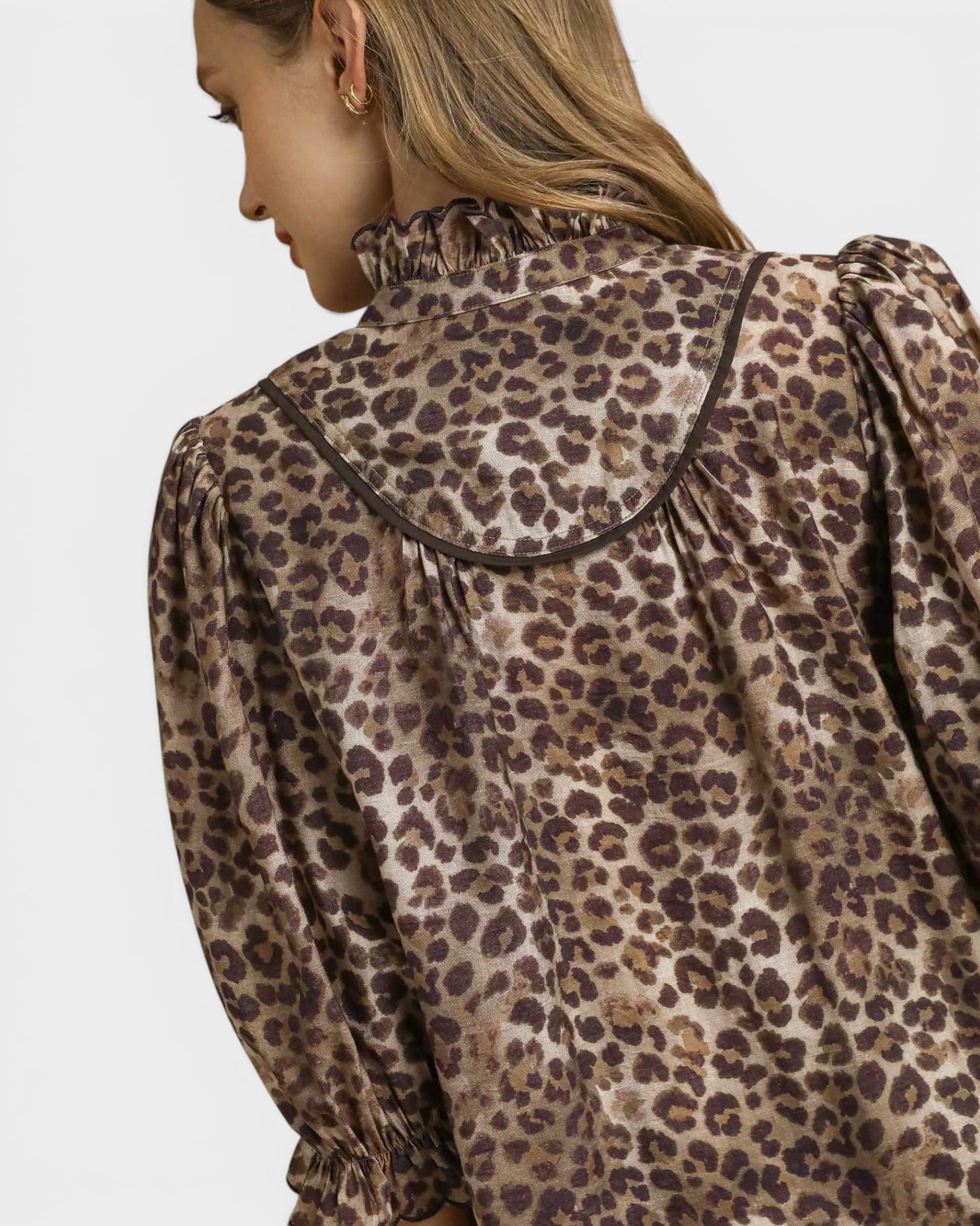 Leopard print jacket worn by a person on a plain background