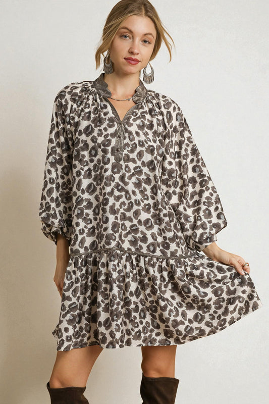 Woman wearing a leopard print dress on a plain background