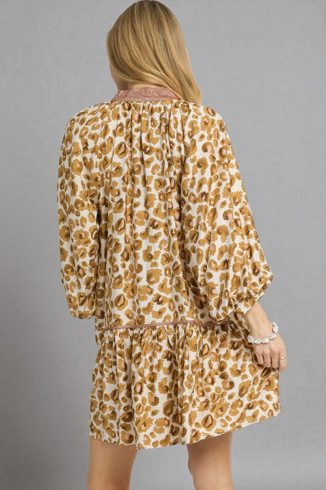 Woman wearing a leopard print dress against a gray background