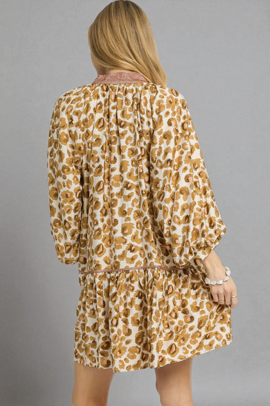 Woman wearing a leopard print dress against a gray background