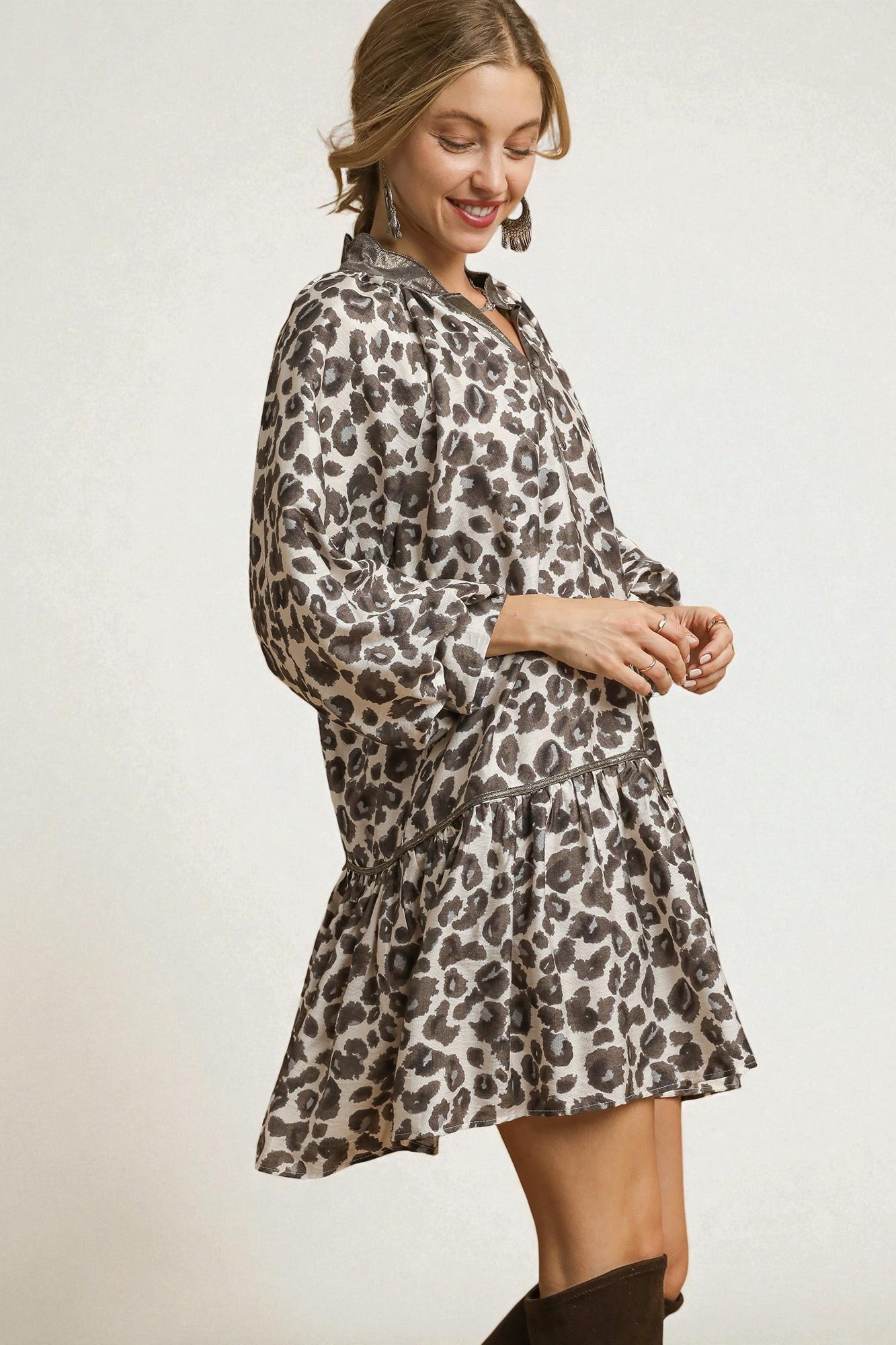 Woman wearing a leopard print dress against a plain background
