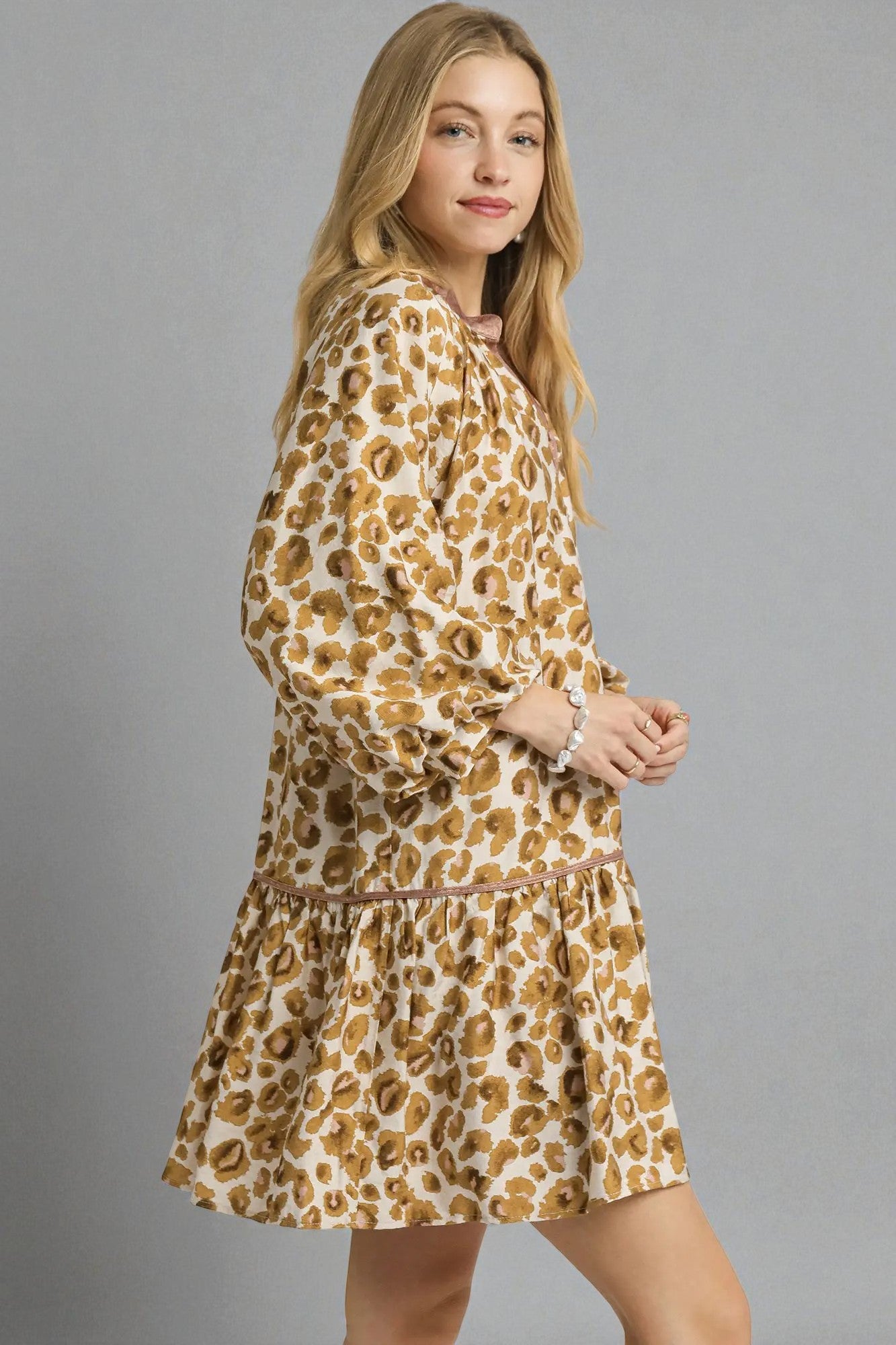Woman wearing a leopard print dress against a gray background