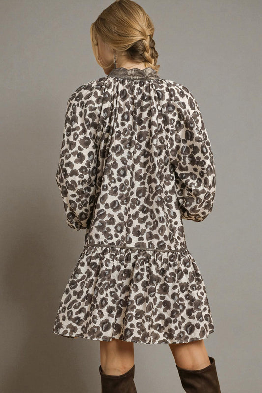 Person wearing a leopard print dress against a gray background