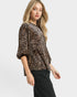 Woman wearing a leopard print top on a white background
