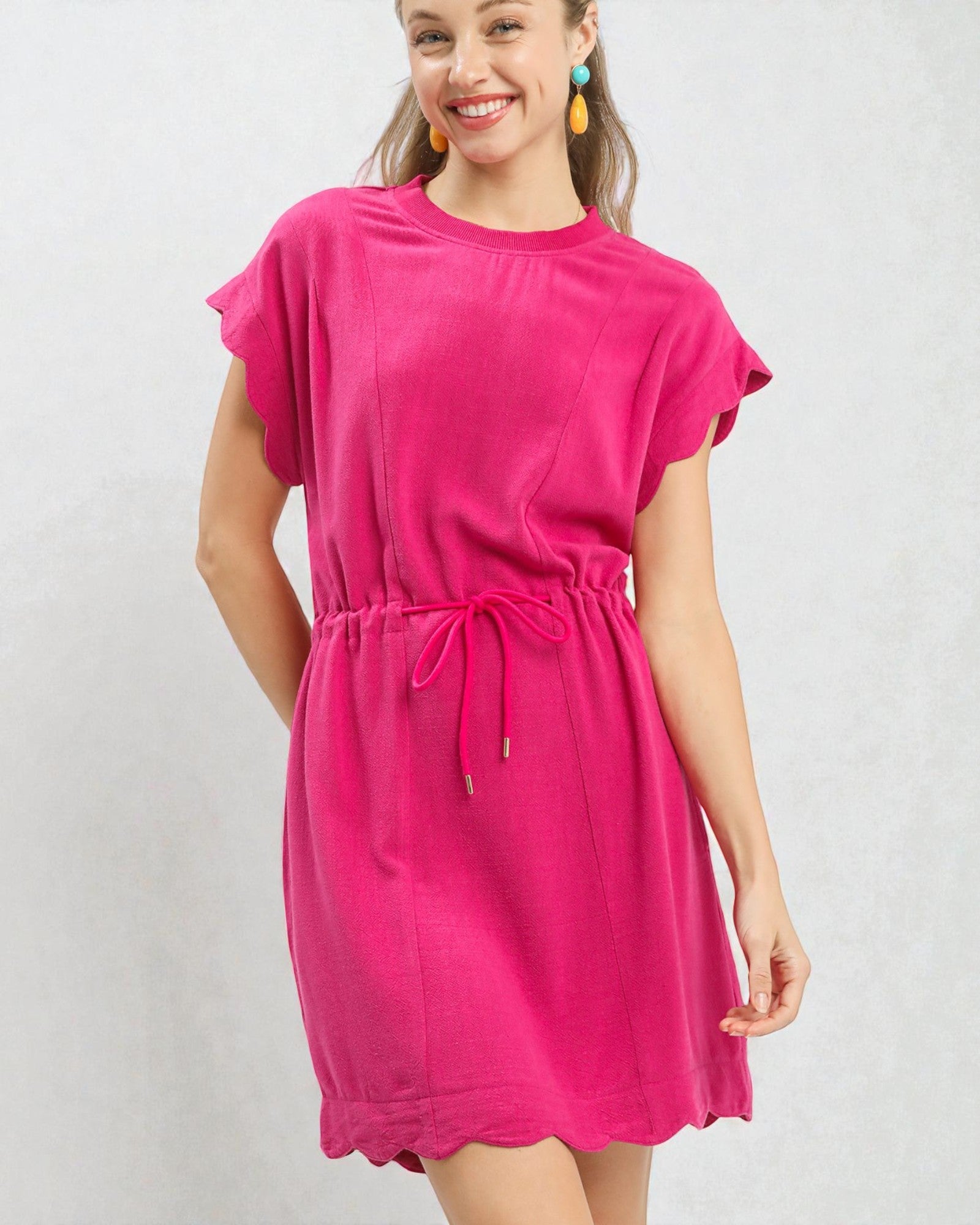 Woman wearing a bright pink dress against a plain background