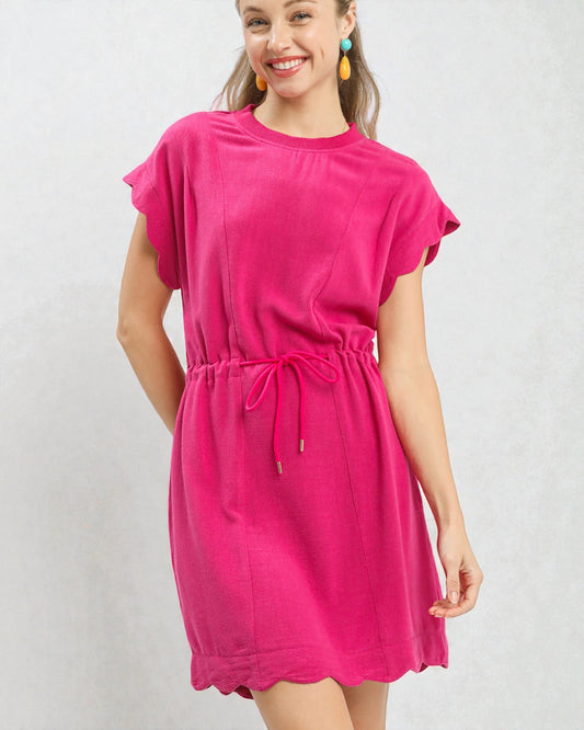 Woman wearing a bright pink dress against a plain background