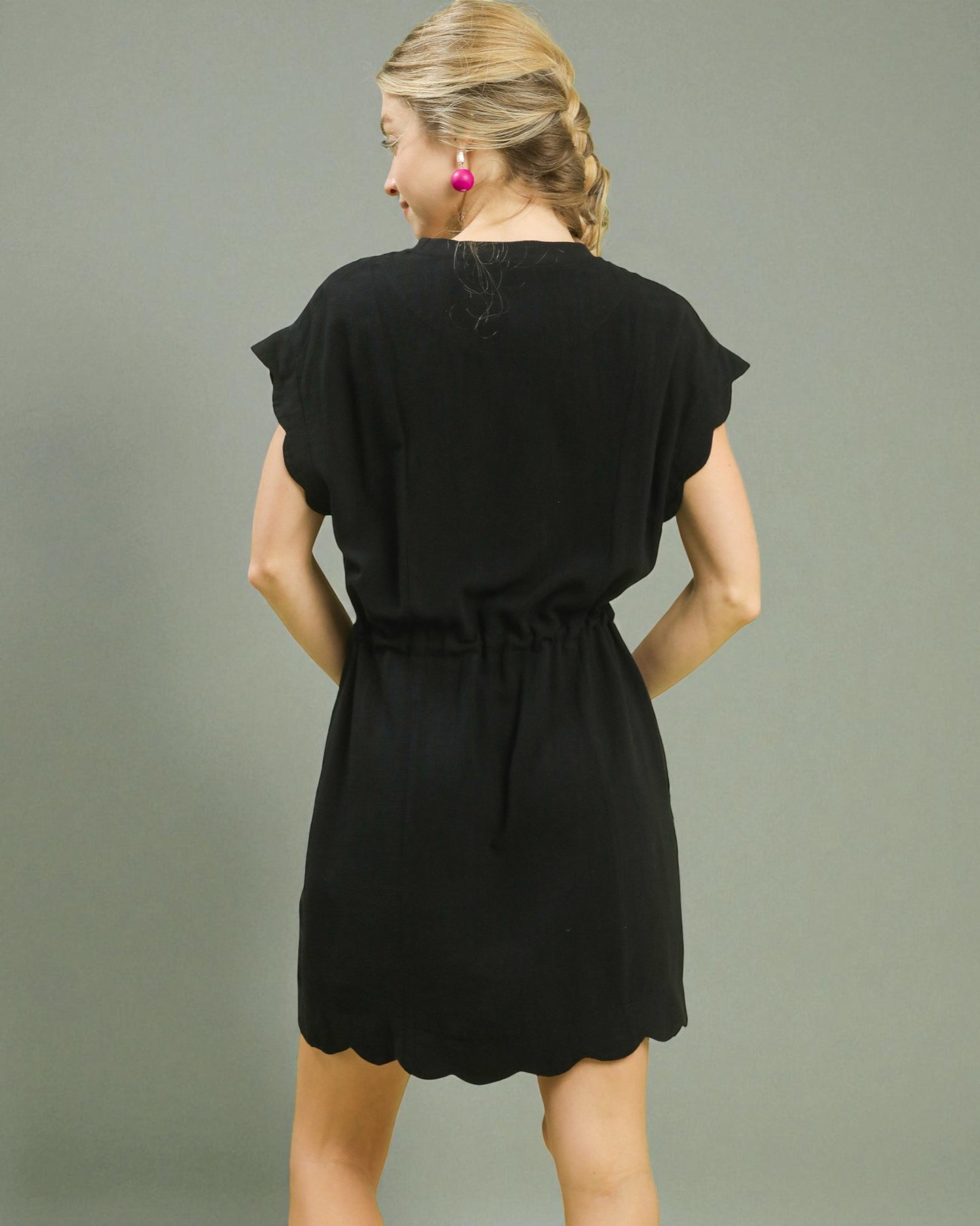 Woman wearing a black dress against a gray background