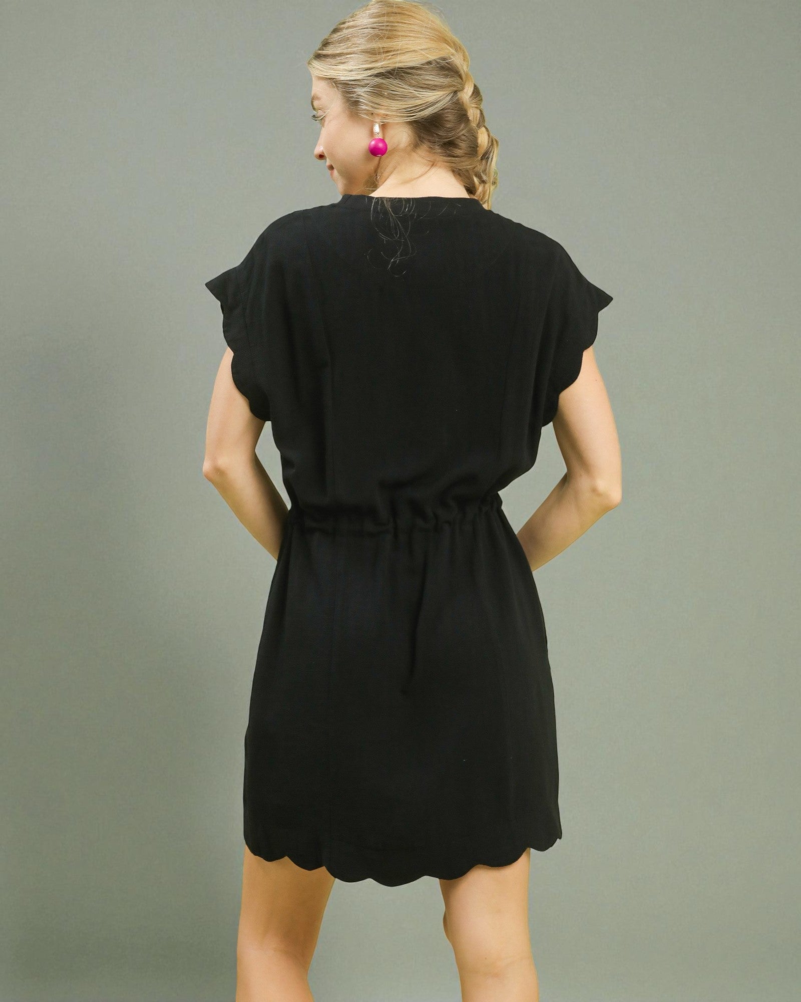 Woman wearing a black dress against a gray background