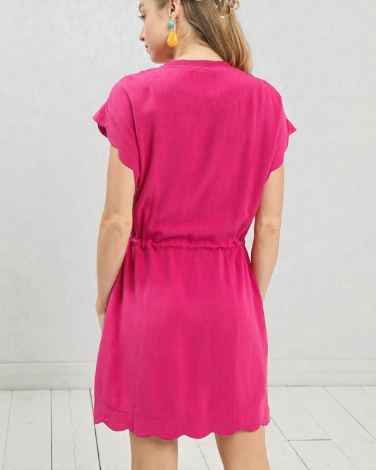 Person wearing a bright pink dress against a white background