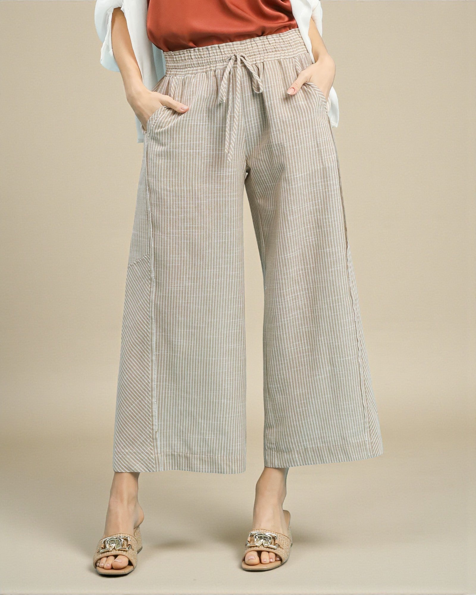 Person wearing checkered wide-leg pants on a beige background