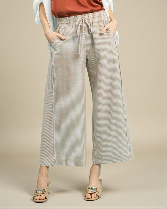 Person wearing checkered wide-leg pants on a beige background