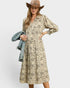 Woman wearing a patterned dress with a denim jacket on a white background