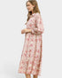 Woman wearing a pink floral dress on a white background