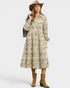 Woman wearing a patterned dress with a hat and boots on a white background