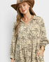 Woman wearing a patterned shirt and hat on a plain background