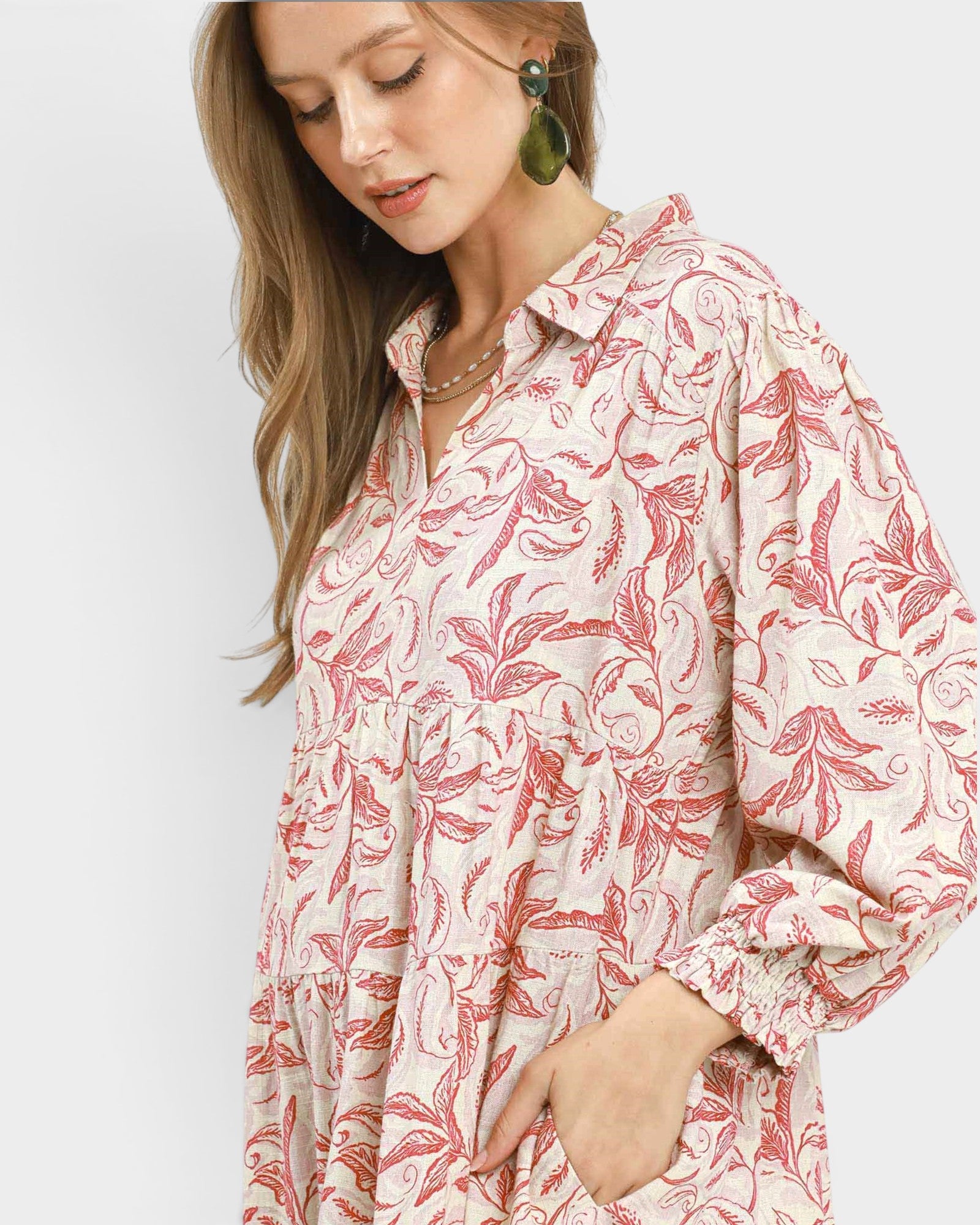 Woman wearing a red and white floral patterned dress on a light gray background