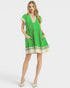 Woman wearing a green dress with white trim on a white background