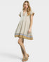 Woman wearing a beige dress with blue trim on a white background