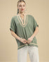 Woman wearing a green top with beige accents on a beige background