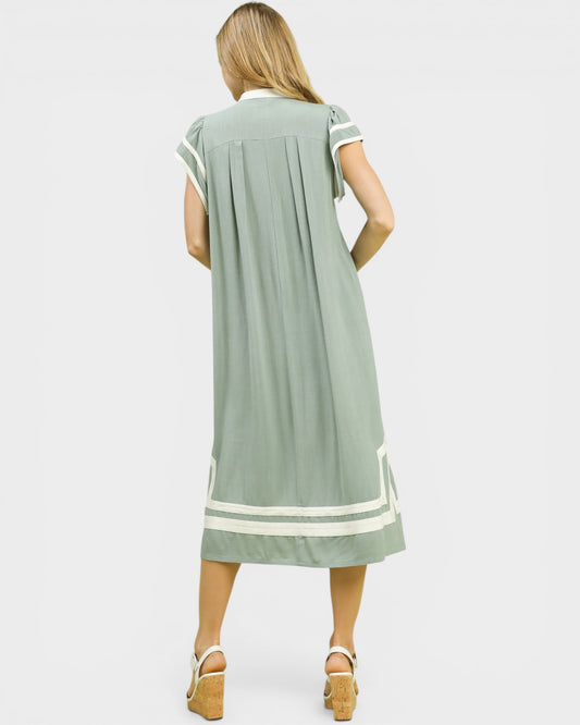 Woman wearing a green dress with white trim on a white background