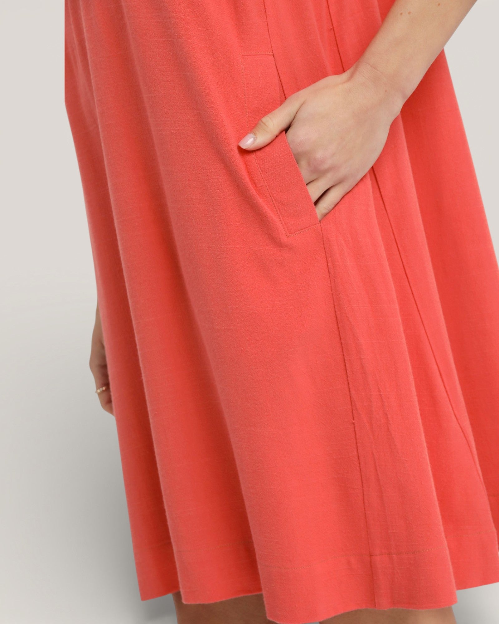 Coral dress with a pocket on a plain background