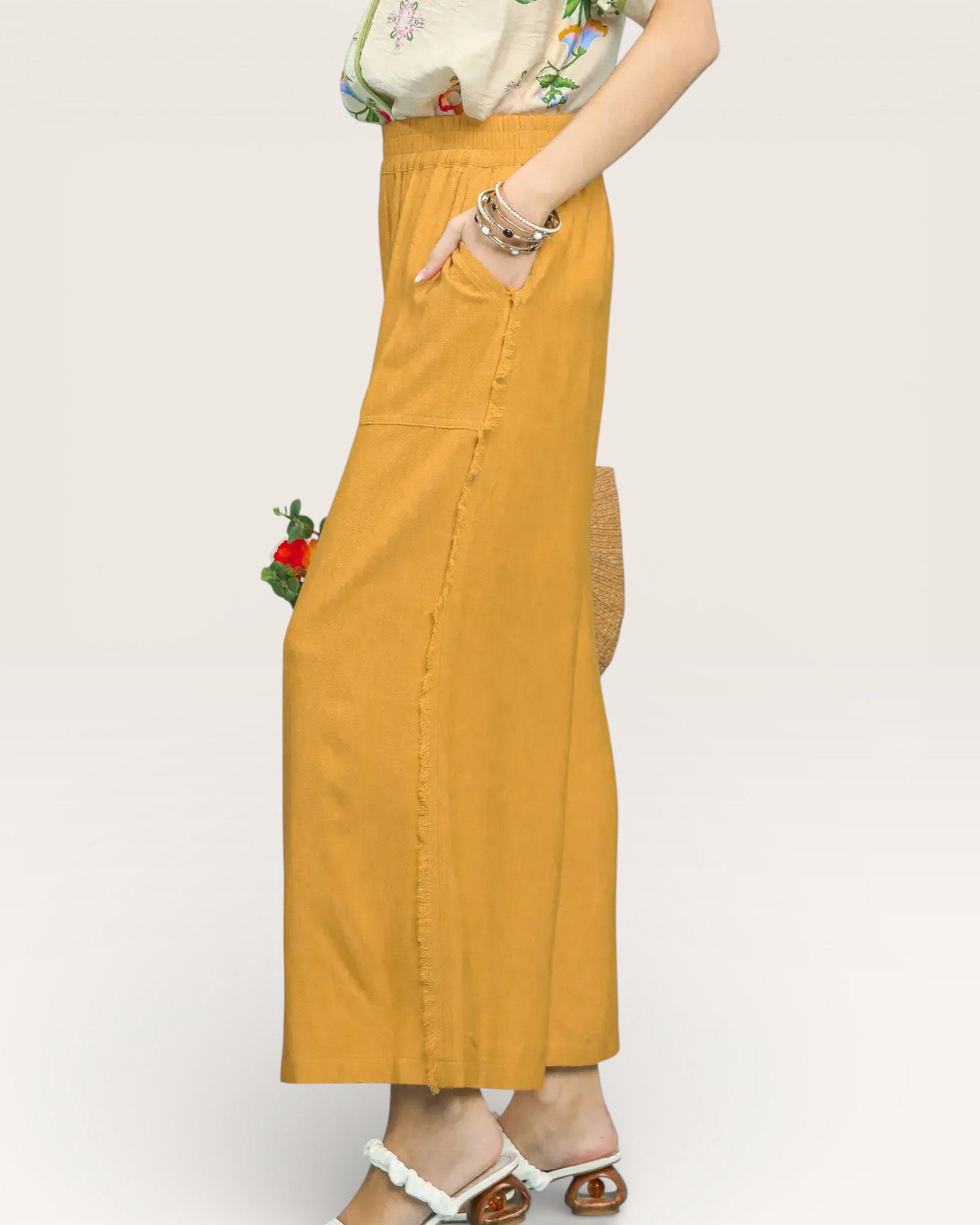 Person wearing a mustard yellow skirt on a plain background