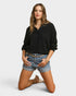 Woman wearing a black sweater and denim shorts on a white background