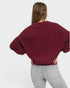 Person wearing a burgundy blouse and gray jeans on a white background