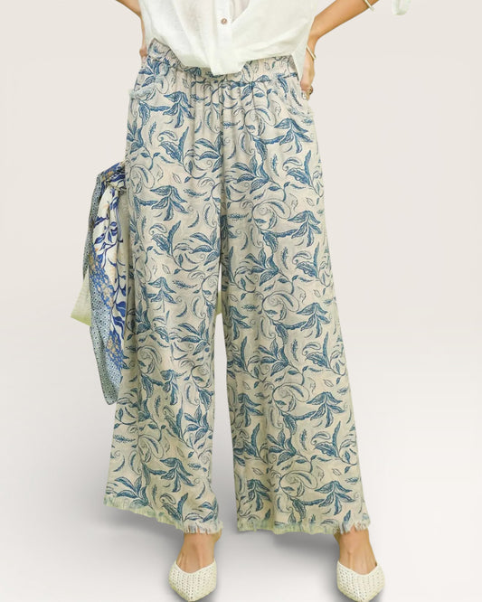 Person wearing floral-patterned pants on a white background