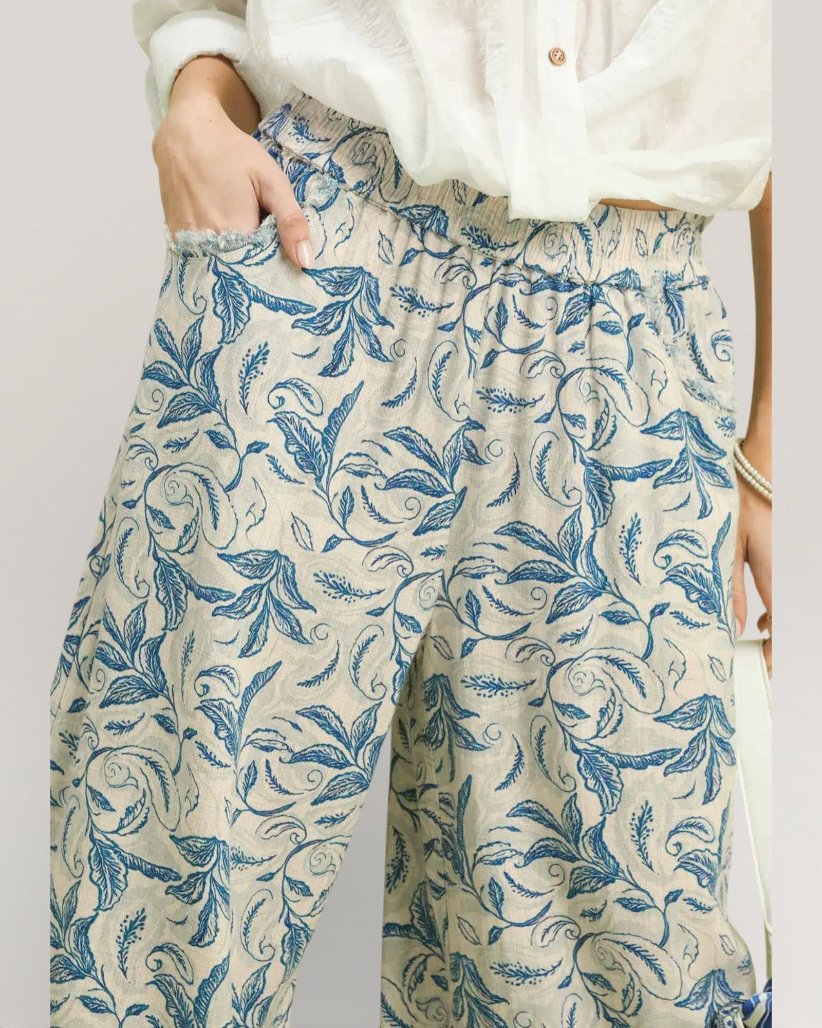 Floral patterned pants worn by a person on a plain background