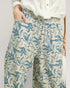 Floral patterned pants worn by a person on a plain background