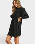 Woman wearing a black dress with puffed sleeves on a white background