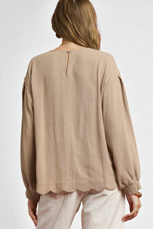 Beige blouse with long sleeves on a white background