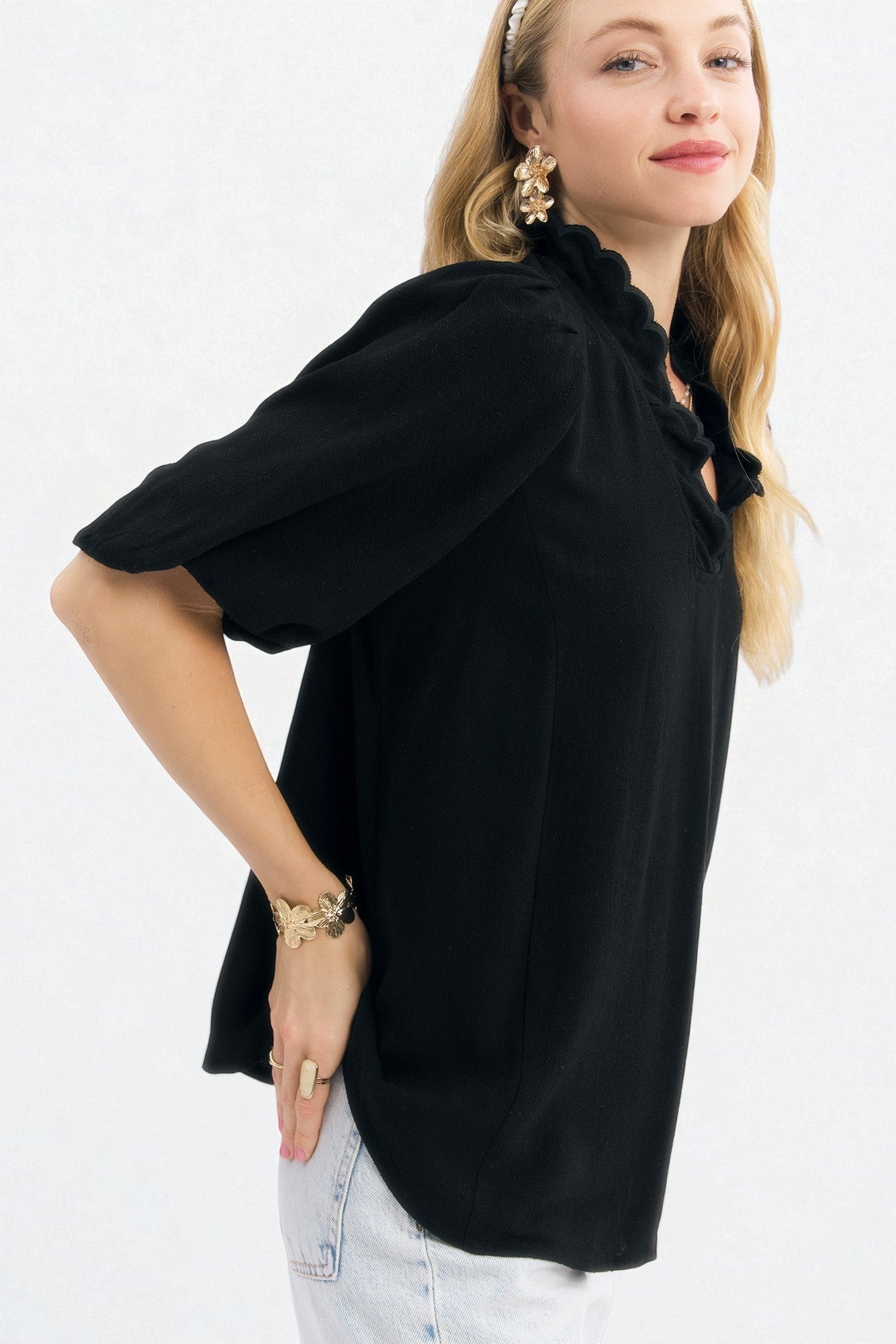 Woman wearing a black blouse with balloon sleeves on a white background