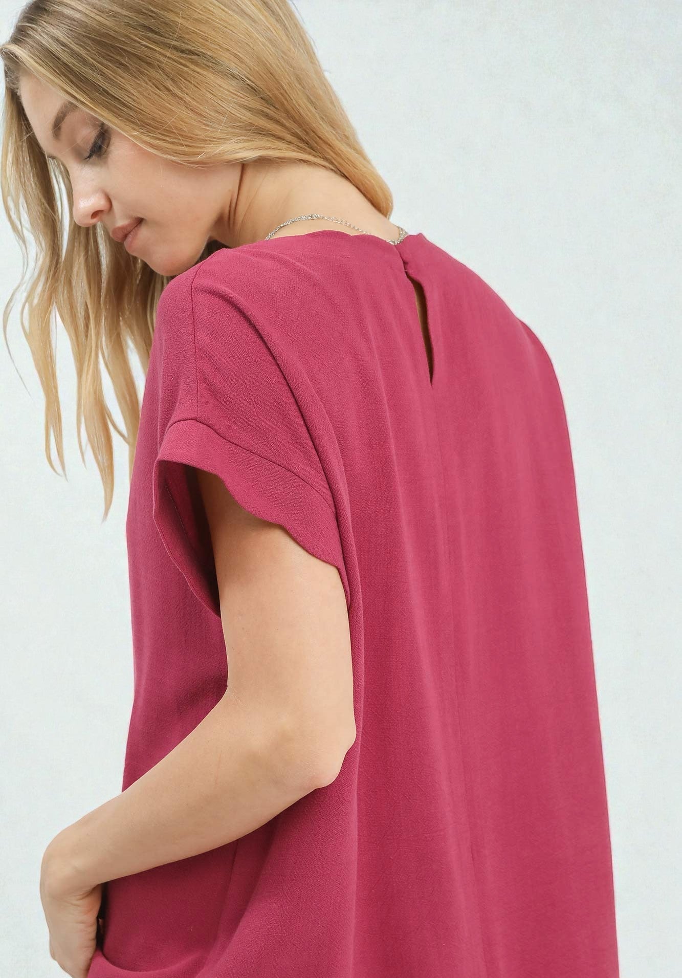 Woman wearing a pink t-shirt against a white background