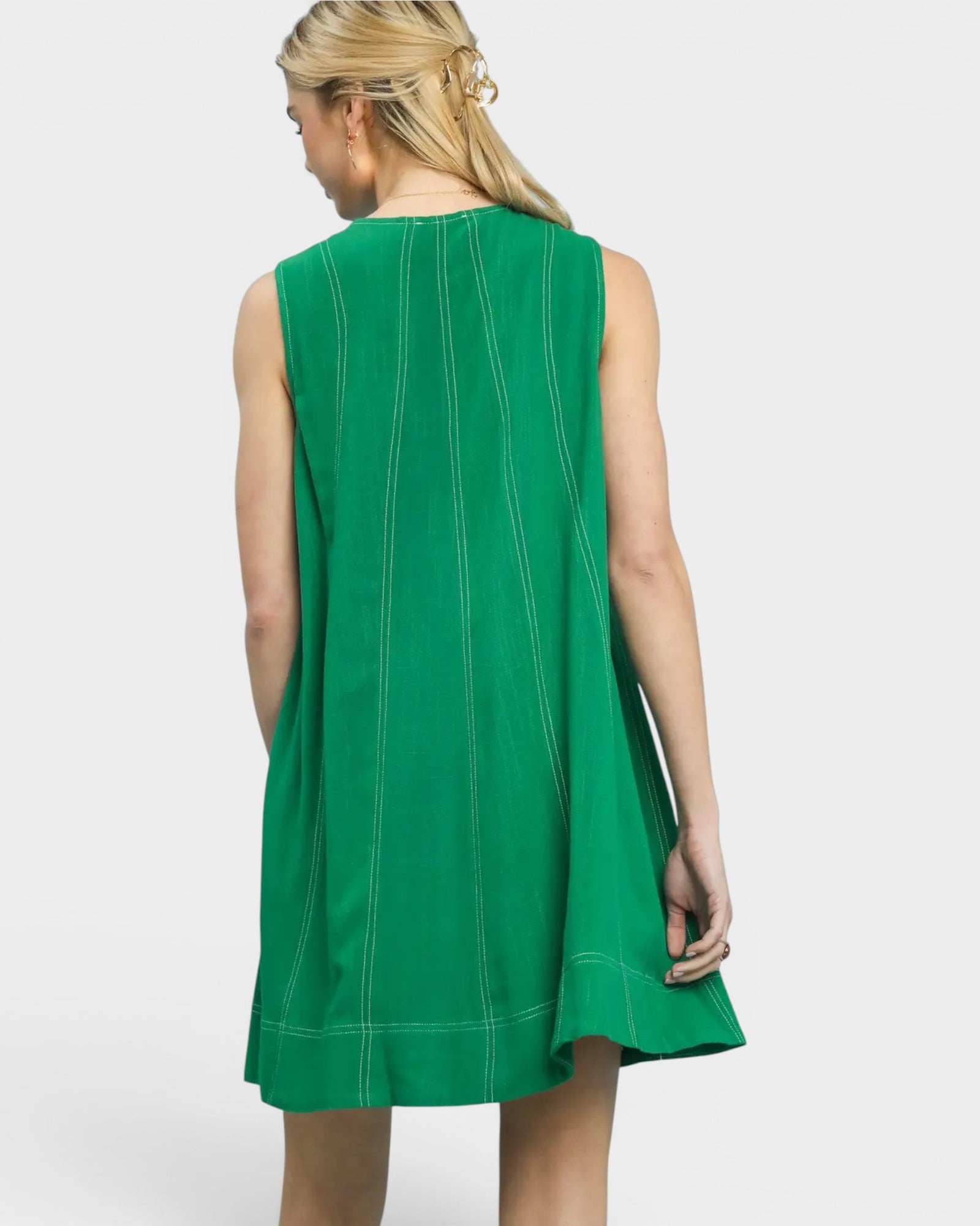 Green sleeveless dress worn by a model on a white background