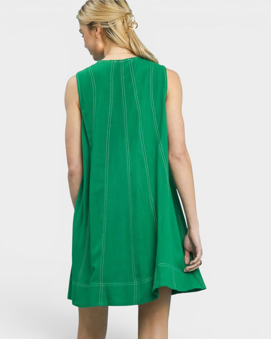 Green sleeveless dress worn by a model on a white background