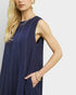 Woman wearing a navy blue sleeveless dress against a white background
