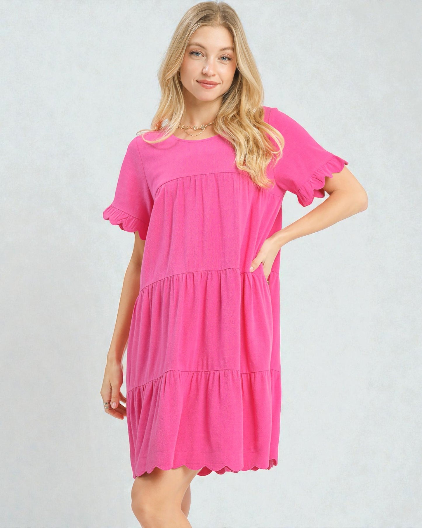 Woman wearing a pink dress on a plain background