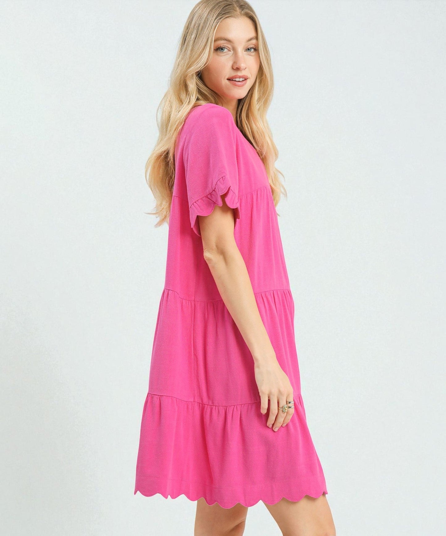 Woman wearing a bright pink dress on a white background