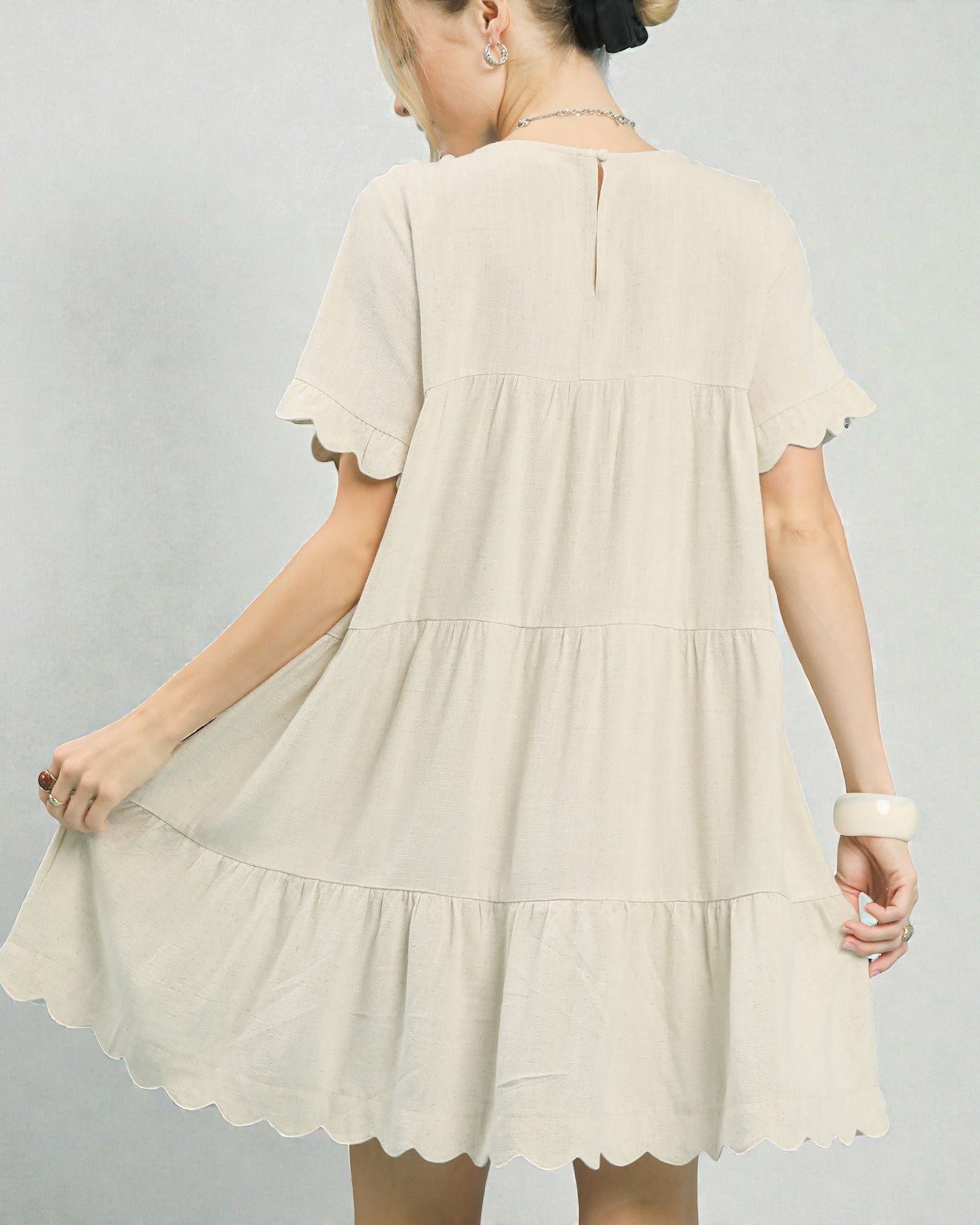 Beige dress worn by a person on a plain background