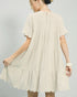 Beige dress worn by a person on a plain background