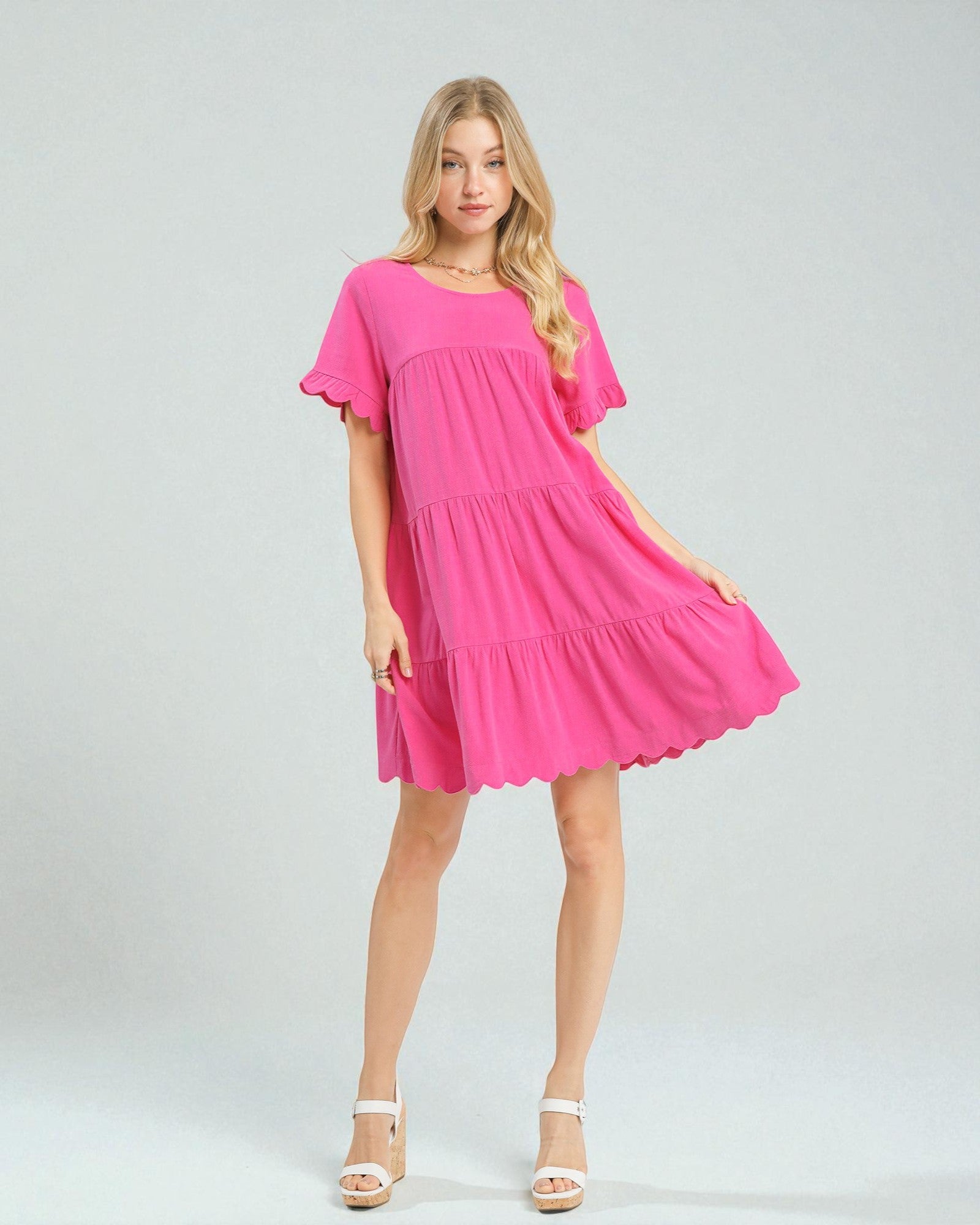 Woman wearing a bright pink dress on a white background