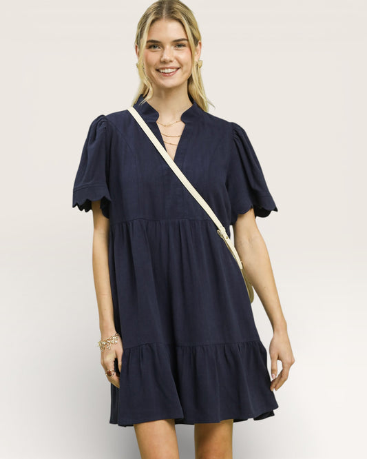 Woman wearing a navy blue dress with a white background