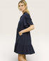 Woman wearing a navy blue dress on a plain background