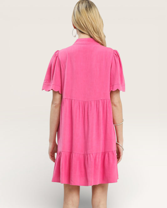 Woman wearing a pink dress against a plain background