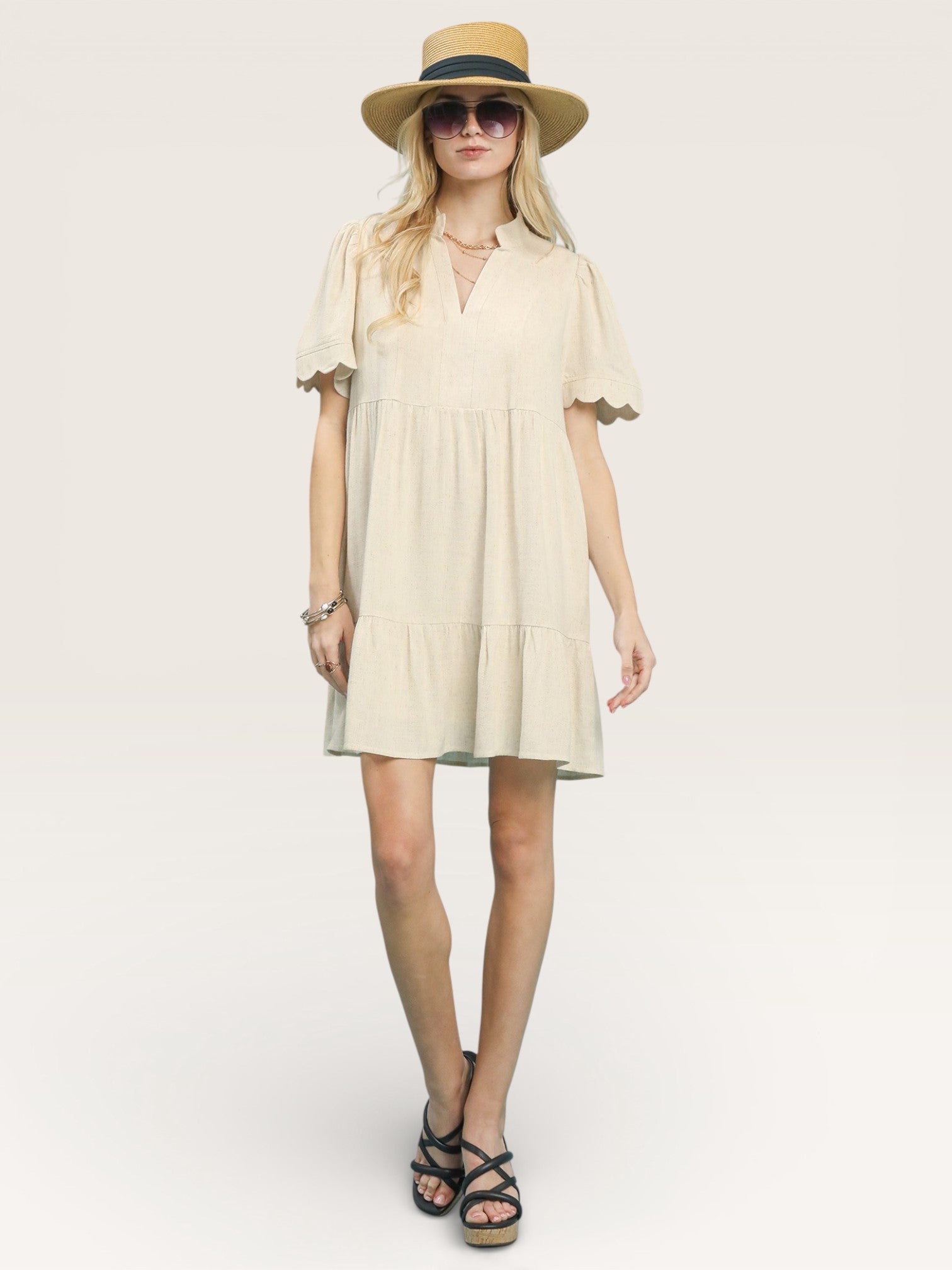 Woman wearing a beige dress and hat on a white background