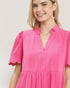 Woman wearing a pink dress with a plain background
