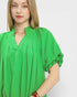 Woman wearing a green blouse with short sleeves on a white background