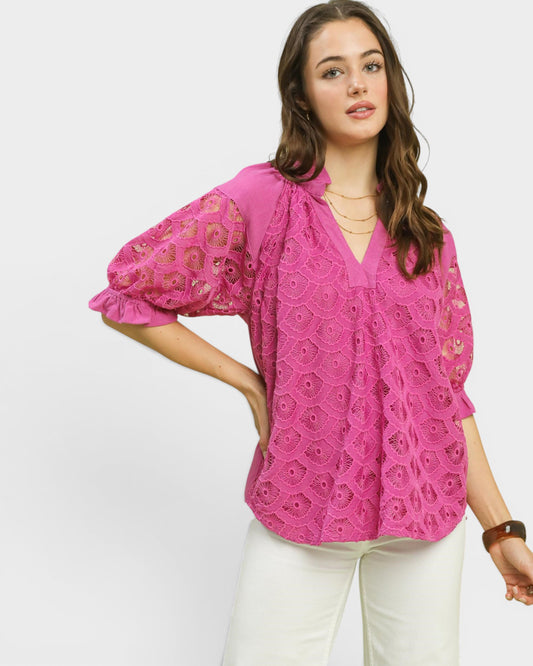 Woman wearing a pink lace blouse on a white background